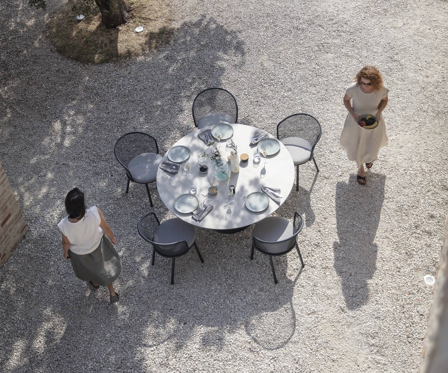 Todus Poltrona design Baza con struttura antracite su un tavolo da pranzo da giardino apparecchiato