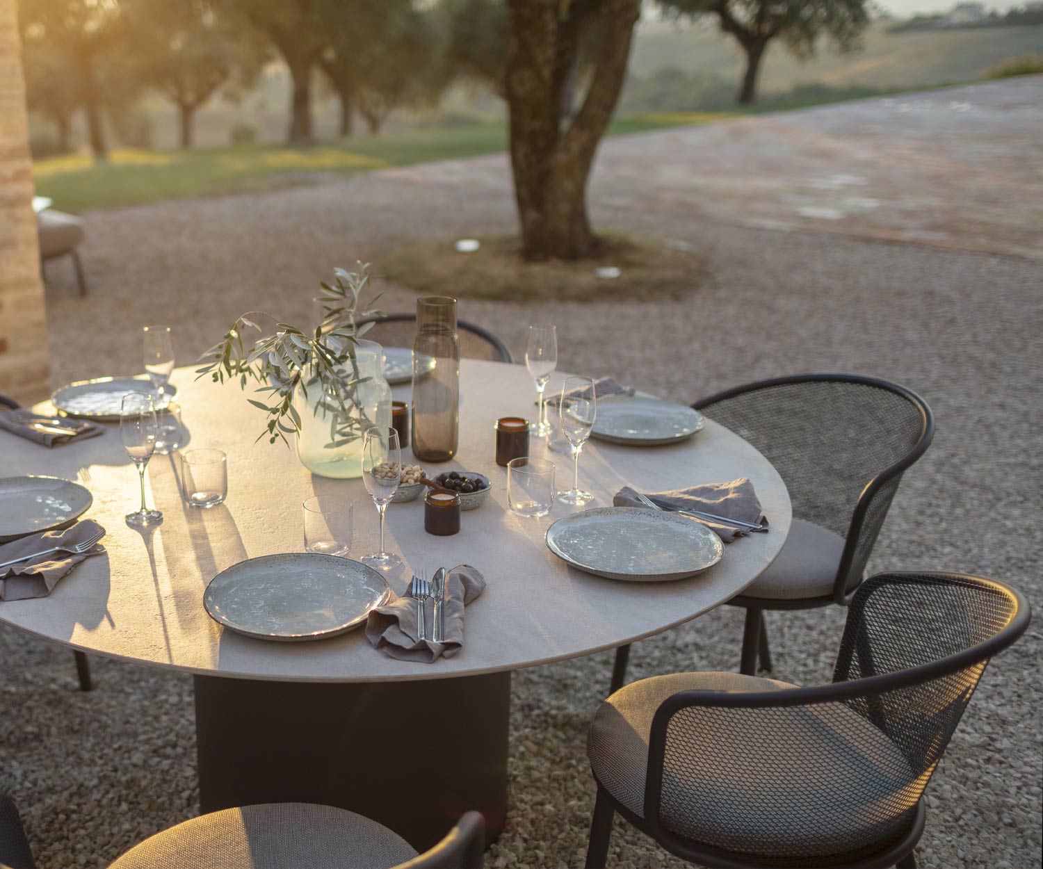 Tavolo da pranzo rotondo Branta per sei persone nel giardino antistante